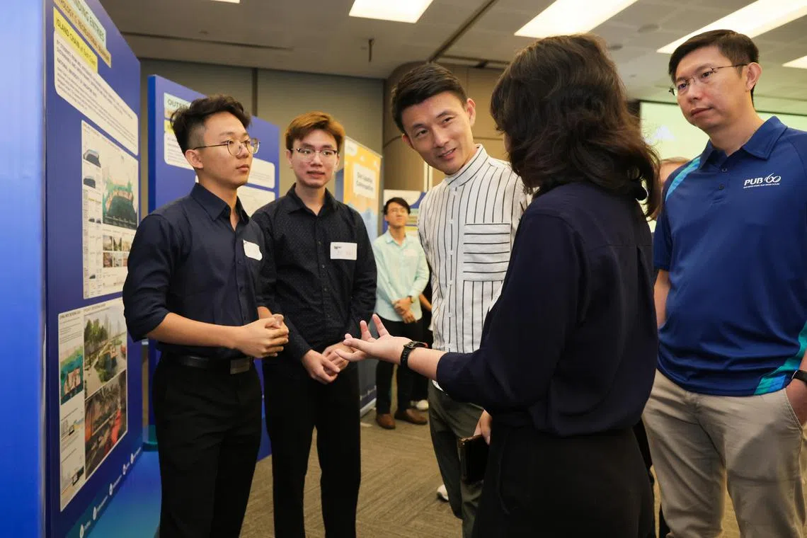 ST20231028_202380349149: Gin Tay/ lhcoast/ Lynda Hong/
Senior Parliamentary Secretary, Ministry of Sustainability and the Environment & Ministry of Transport, Baey Yam Keng (centre) and Goh Si Hou, (far right) Chief Executive of PUB interacts with winners of two projects Trifoliate Horizon and Emerald Coast, (R-L): Yeong Yoong Sze 22, Environmental engineering/ Year 4 ; Tan Zhi Xian 21, Environmental engineering/Year 3 ; and Yew Jun Hao 21, Environmental engineering with a second major in society and urban systems/Year 3;  photographed at Second Phase of Our Coastal Conversation engagement session held at Environment Building on Oct 28, 2023