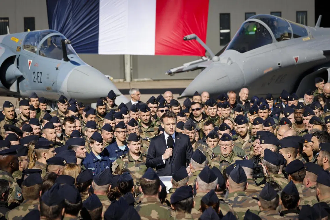 epa11972097 France's President Emmanuel Macron (C) delivers a speech in front of a Dassault Mirage 2000 (L) and a Dassault Rafale (R) fighter aircrafts during his visit to the Luxeuil-Saint-Sauveur Air Base in Saint-Sauveur, north-eastern France, 18 March 2025.  EPA-EFE/LUDOVIC MARIN / POOL  MAXPPP OUT
