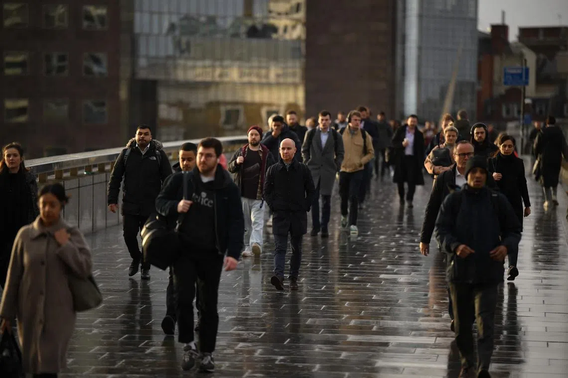 Commuters on their way to work cross London Bridge in central London on January 3, 2023. 