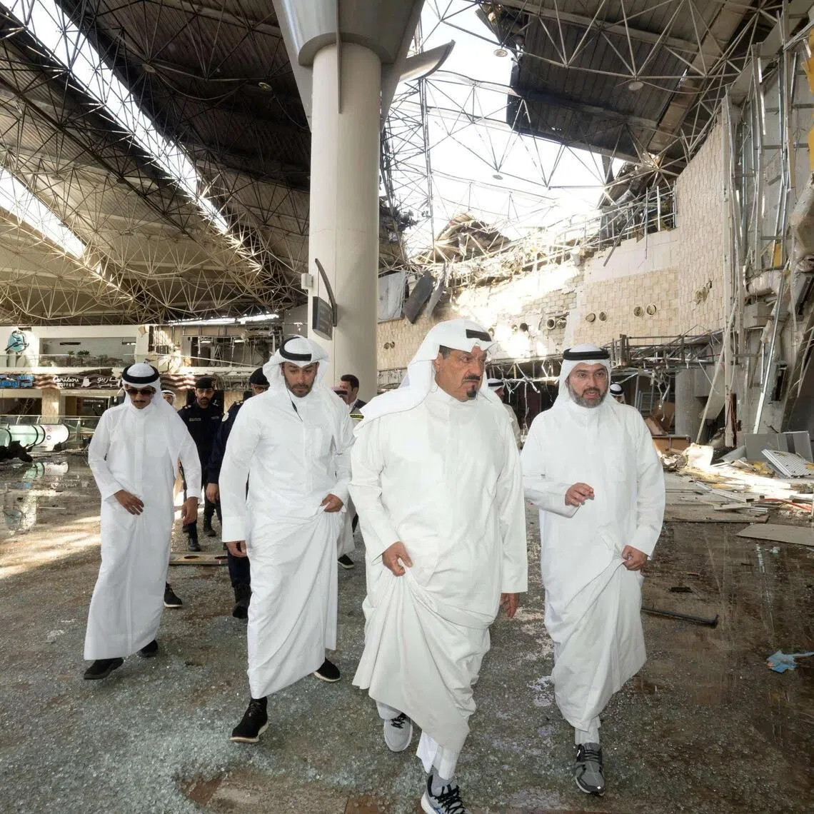 Kuwaiti officials inspecting damage inside a terminal at Kuwait International Airport following a drone and missile attack on June 3.
