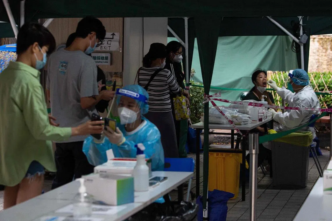 A health worker (R) takes a swab during Covid-19 tests of the entire population in Macau on Nov 1, 2022. 