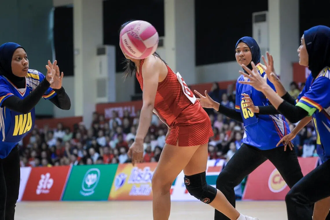 The ball passed by a Malaysian player obscures the head of Singapore’s Jamie Lim during the SEA Games netball final at Chanthana Yingyong Gymnasium in Bangkok on Dec 17.