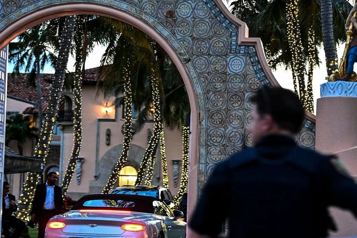 A security guard checks a visitor entering former US President Donald Trump's Mar-a-Lago club in Palm Beach, Florida on March 30, 2023. - A New York grand jury has voted to indict former US president Donald Trump over hush money payments made to porn star Stormy Daniels ahead of the 2016 election, multiple US media reported on March 30, 2023. (Photo by CHANDAN KHANNA / AFP)