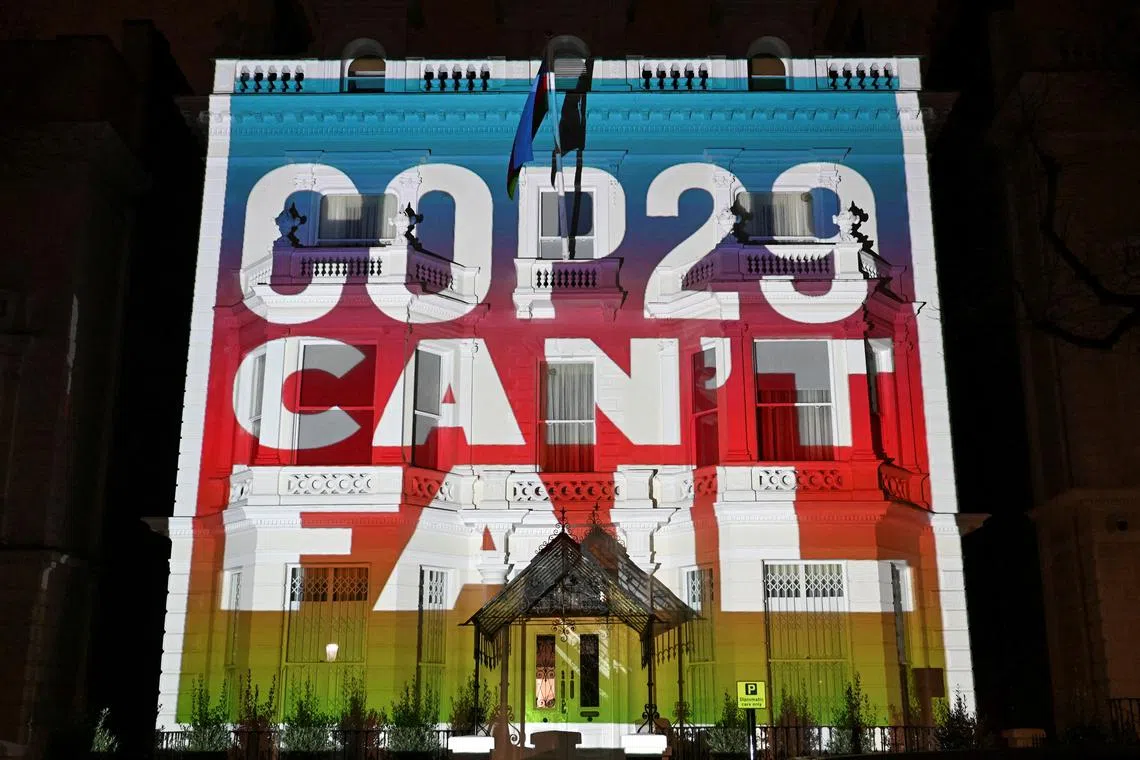 Climate activists project a message onto the Embassy of Azerbaijan ahead of COP29 climate talks, in London, Britain, November 7, 2024. REUTERS/Chris J. Ratcliffe/File Photo