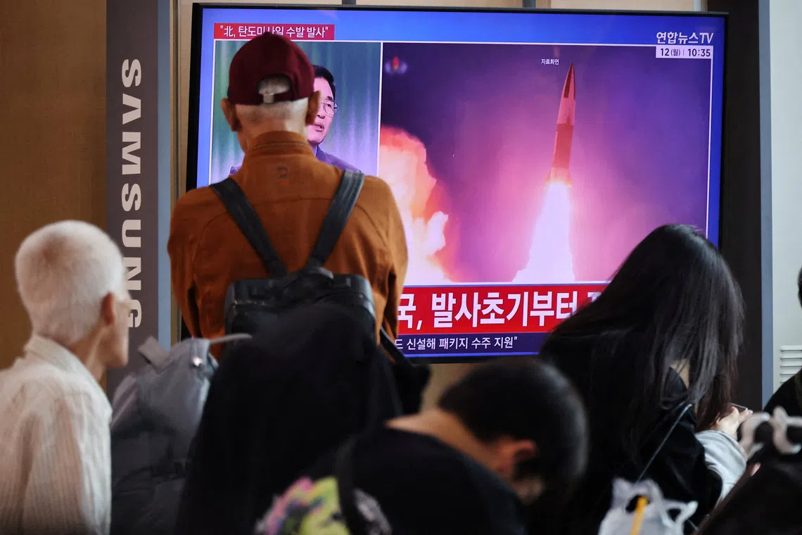 People watching a news report on North Korea firing multiple ballistic missiles toward the sea off its east coast, at a railway station in Seoul on Oct 12.
