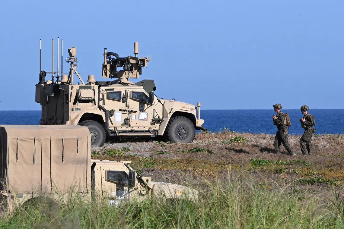 US marines walking past a Marine Air Defence Integrated system launcher during the integrated missile exercise as part of the Balikatan joint Philippines and US military exercise at a naval base facing South China Sea.
