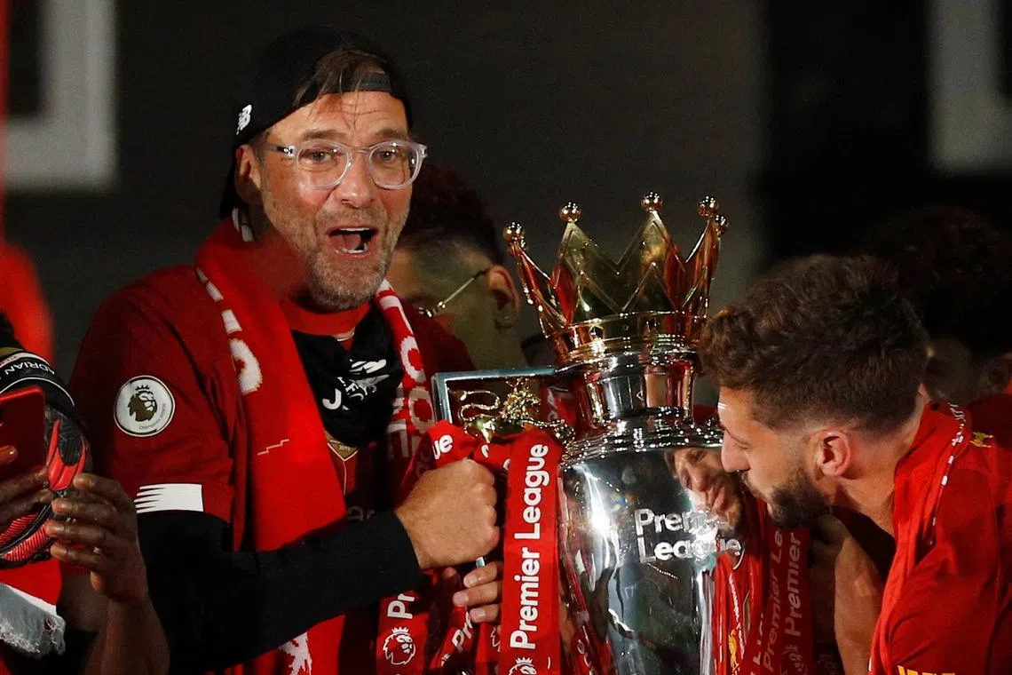 FILE PHOTO: Soccer Football - Premier League - Liverpool v Chelsea - Anfield, Liverpool, Britain - July 22, 2020 Liverpool manager Juergen Klopp celebrates with the trophy after winning the Premier League Pool via REUTERS/Phil Noble/File Photo