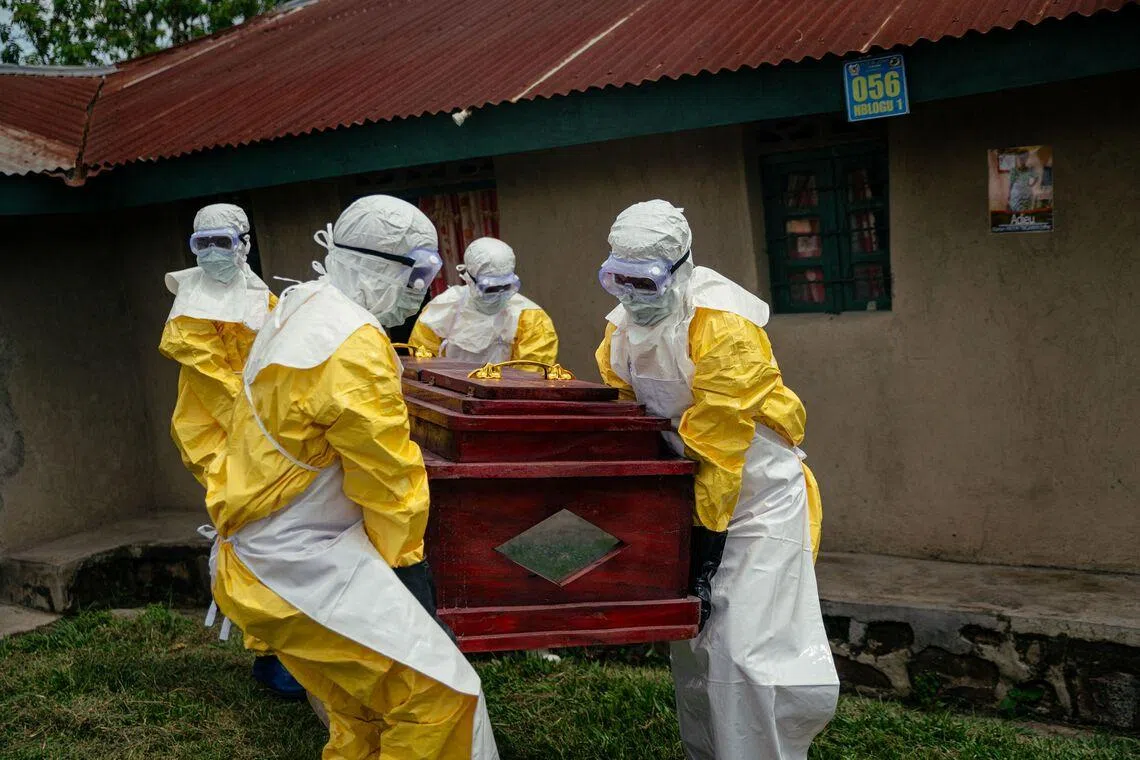 Members of a Congolese Red Cross team wearing personal protective equipment carrying the coffin of a woman suspected of having died from Ebola virus disease ahead of her safe burial at her home in Bunia, on June 7, 2026. 