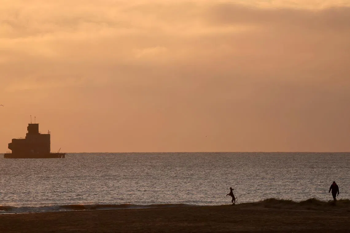 FILE PHOTO: People visit the beach, near the location where a tanker carrying jet fuel for the U.S. military was hit by a container ship, off the coast of Cleethorpes, Britain, March 12, 2025. REUTERS/Phil Noble/File Photo