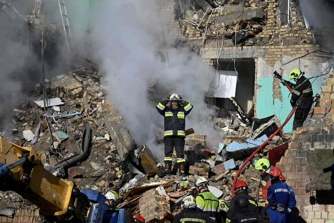 Ukrainian rescuers conducting a search and rescue operation at a residential building hit during a Russian drone and missile attack on Kyiv that killed at least 18 people.