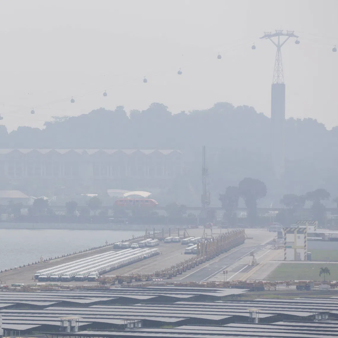 Hazy conditions seen from Tanjong Pagar Distripark towards Sentosa. When in becomes chairman of ASEAN in 2027, Singapore should encourage investments in projects that make it lucrative to prevent fires, the writer says.