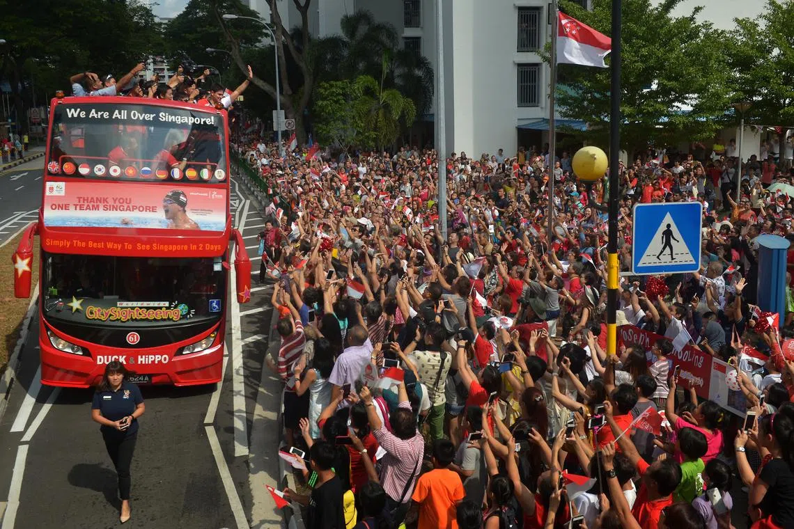 Singapore's first Olympic champion Joseph Schooling on his victory parade bus as it reaches it's first pit stop at Blk 50A Marine Terrace market on Aug 18, 2016. He was greeted like a rock star as nearly 10,000 turn up for three-hour victory parade