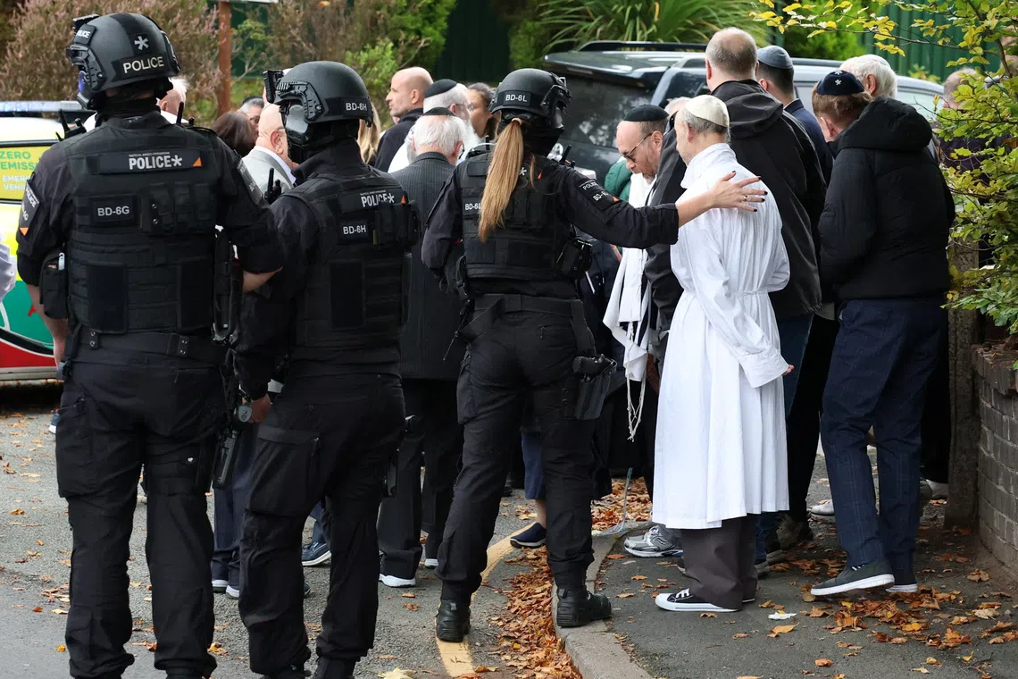 People gather near the scene, after a report of an incident in which a car was driven at pedestrians and a stabbing attack, near a synagogue in north Manchester, Britain, October 2, 2025. REUTERS/Phil Noble