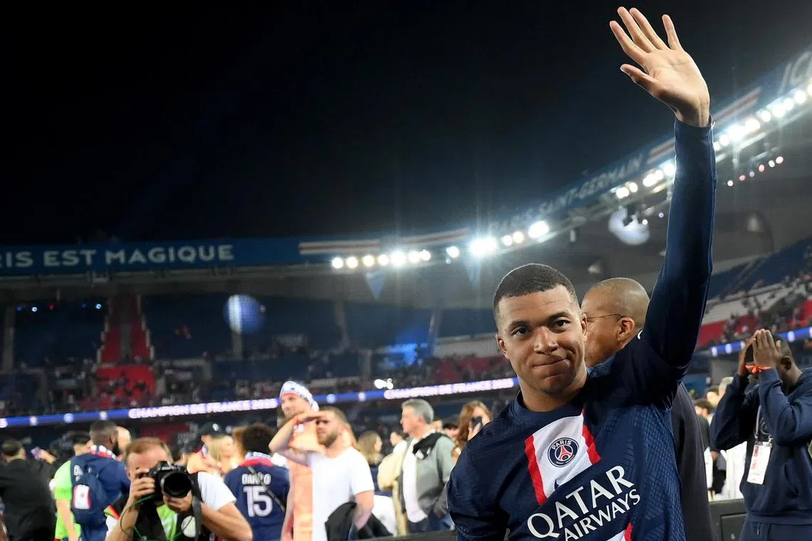 Paris Saint-Germain forward Kylian Mbappe waving to the crowd duing the 2022-2023 Ligue 1 championship trophy ceremony after the game against Clermont Foot 63 in Paris.