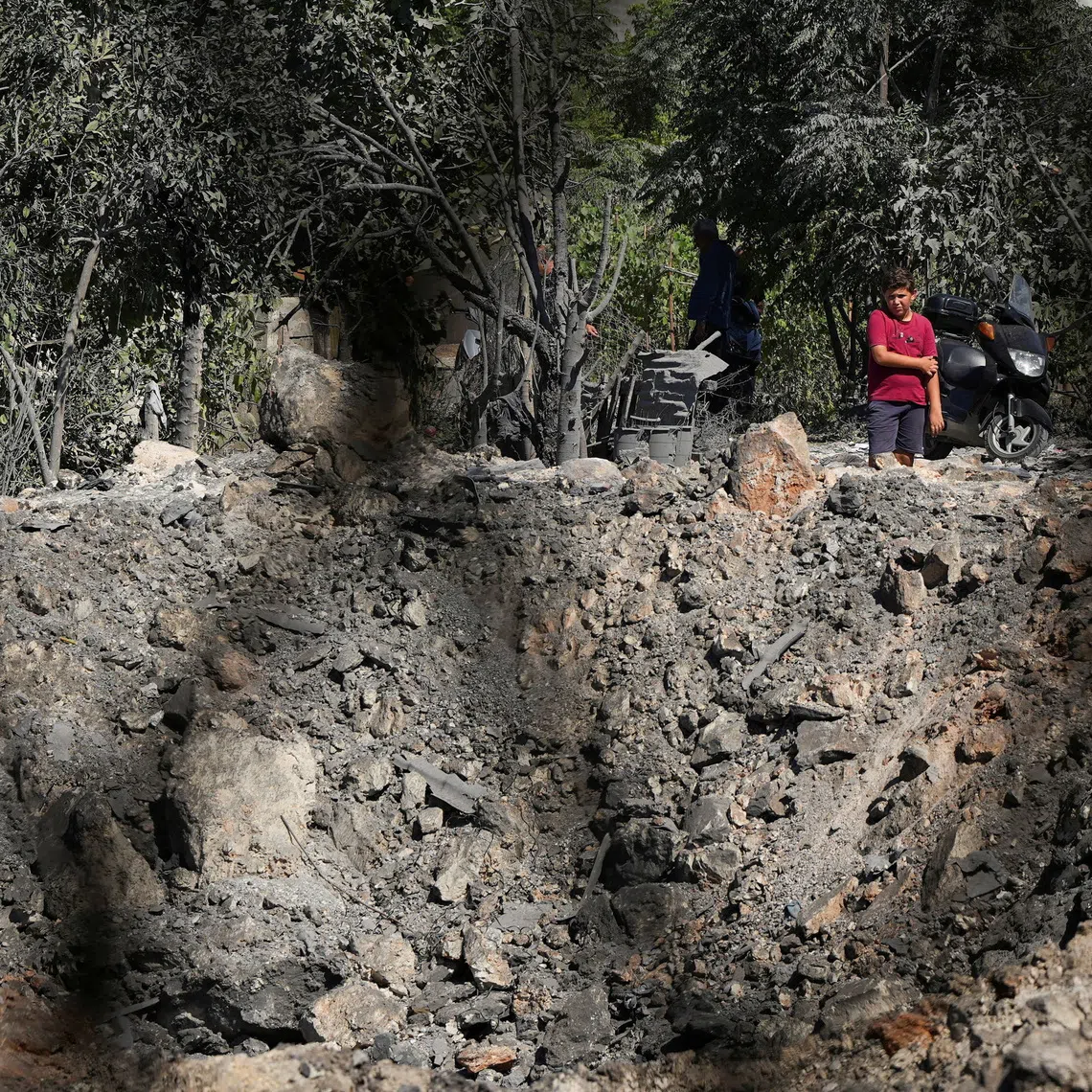 People and journalists stand at a site hit by Israeli strikes that occurred in the early hours of Thursday, according to Lebanon’s state news agency NNA, in Burj al-Shamali, southern Lebanon, August 6, 2026. REUTERS/Stringer