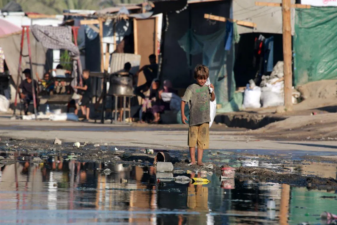 A young Palestinian boy standing barefoot near stagnant wastewater in Deir el-Balah, in the central Gaza Strip, on July 19.