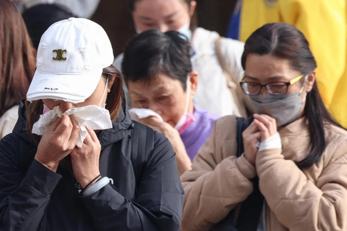 Relatives react after identifying family members from photos at Kwong Fuk Community Hall in Tai Po, Hong Kong, on Nov 27.