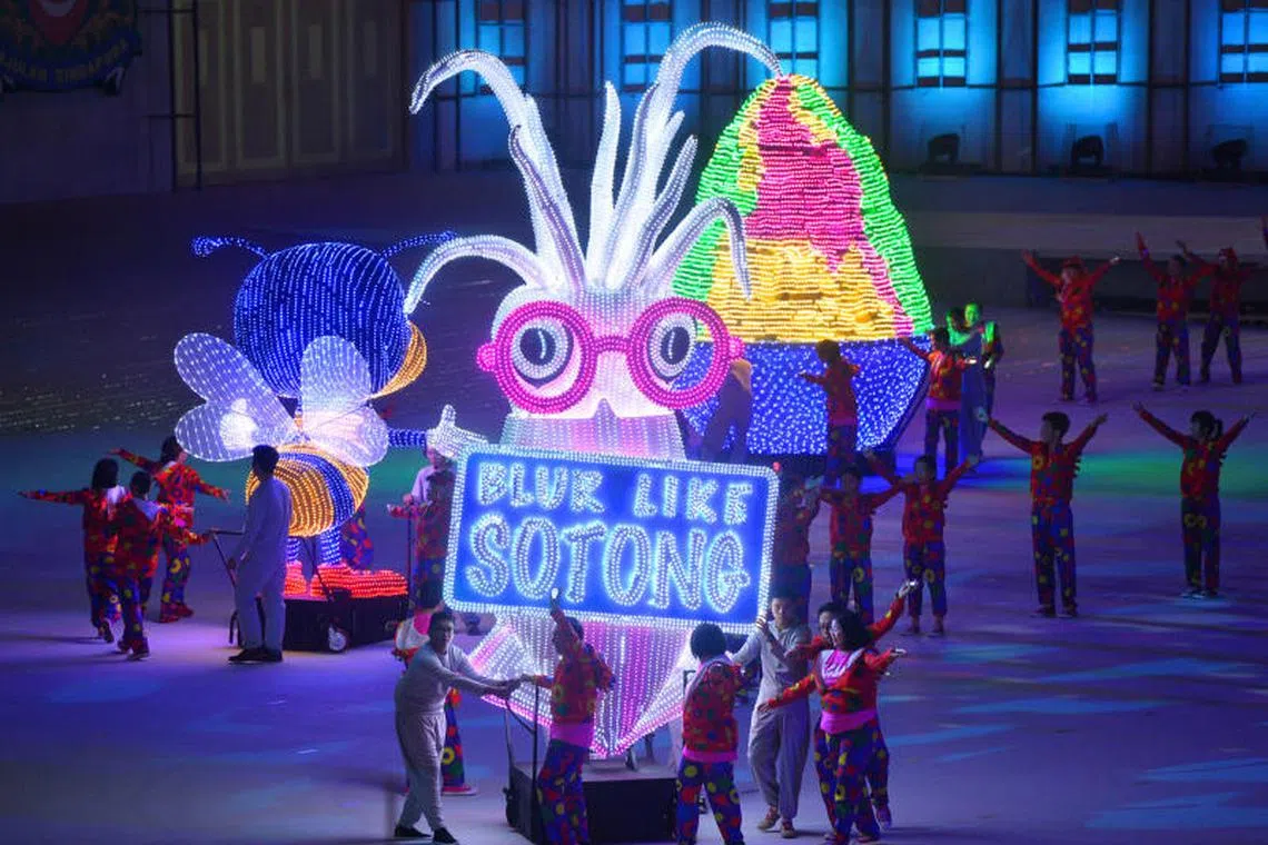 Performers from the People’s Association with large props showcasing Singapore’s unique identity at the preview of the National Day Parade at Padang on Aug 1, 2015.