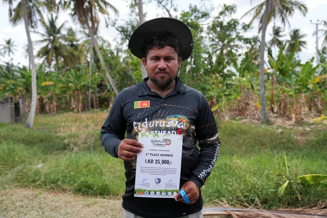 Vimukthi Sandaruwan, 37, winner of the fishing competition, holds his first-place certificate after the prize-giving in Wariyapola, Sri Lanka, September 20, 2025. REUTERS/Thilina Kaluthotage