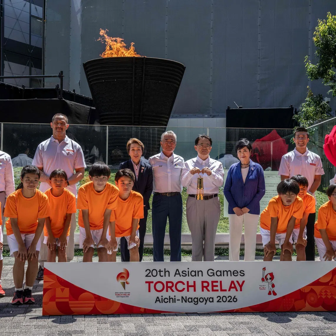 (Back L-R) Mayor of Nagoya Ichiro Hirosawa, former Japanese hammer throw athlete Koji Murofushi, President of the Japan Olympic Committee Seiko Hashimoto, Vice President of the Olympic Council of Asia Tsunekazu Takeda, Governor of Aichi Prefecture Hideaki Omura, Governor of Tokyo Yuriko Koike and Japanese sprinter Yoshihide Kiryu pose during the torch lighting ceremony for the 2026 Asian Games, outside the National Stadium in Tokyo on August 18, 2026. About 15,000 competitors and officials are expected at the event, which takes place in Nagoya and the wider Aichi area from September 19 to October 4. (Photo by Yuichi YAMAZAKI / AFP)