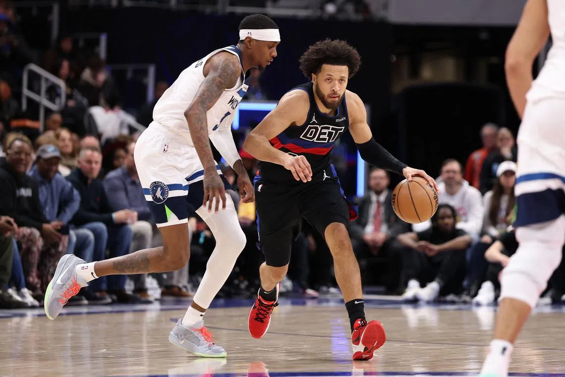Cade Cunningham of the Detroit Pistons drives around Jaden McDaniels of the Minnesota Timberwolves during the first half at Little Caesars Arena.