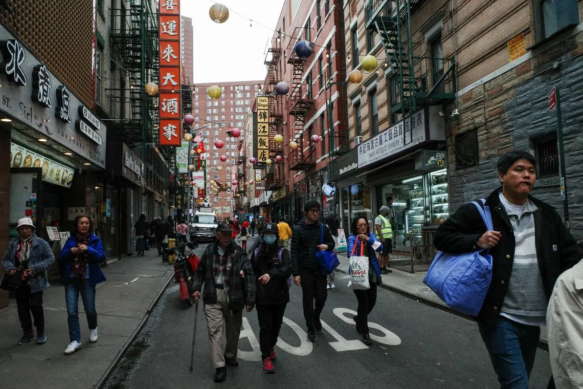 Tourists and pedestrians walk down Pell Street in the Chinatown neighborhood of Manhattan in New York City, U.S., April 14, 2025.  REUTERS/Bing Guan/File Photo