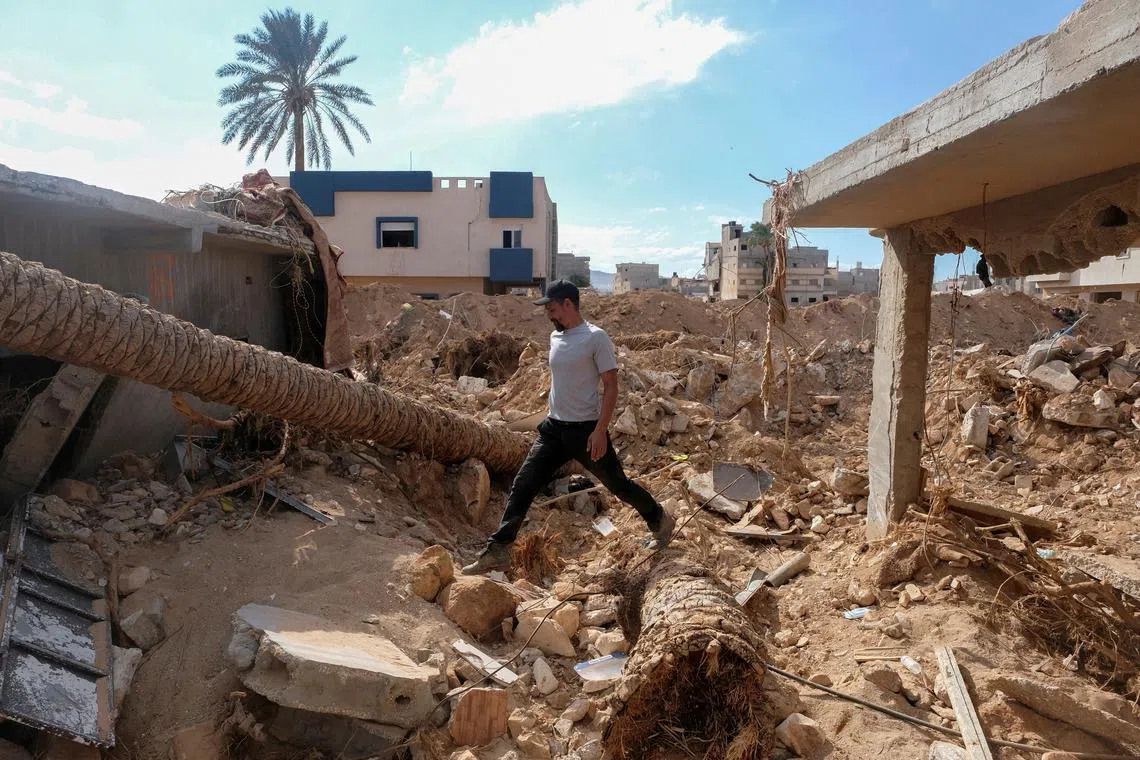 FILE PHOTO: Abdul Salam Ibrahim Al-Qadi, 43 years old, walks on the rubble in front of his house, searching for his missing father and brother after the deadly floods in Derna, Libya, September 28, 2023. REUTERS/Esam Omran Al-Fetori/File Photo