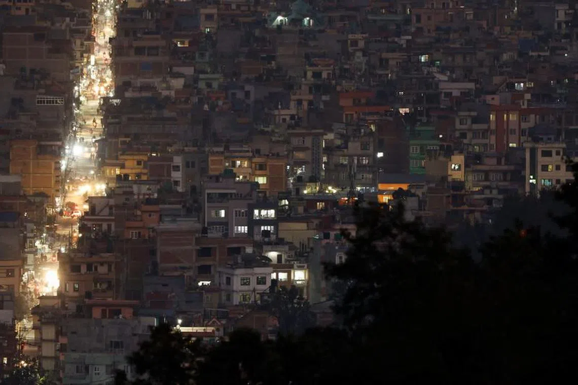 FILE PHOTO: Light illuminates a street between the cluster of residential buildings in Kathmandu, Nepal November 8, 2022. REUTERS/Navesh Chitrakar/File Photo