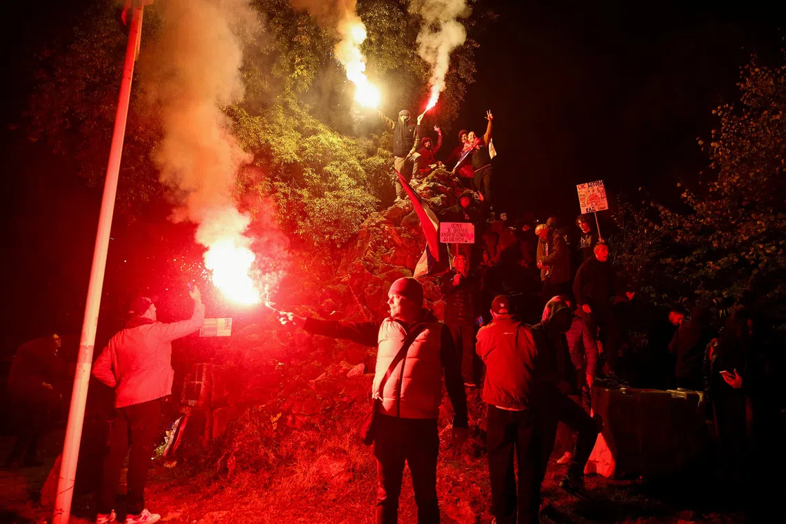 Image 6: People light flares as supporters of the electoral list "Student List - Students Win" celebrate following the first results of the parliamentary election in Belgrade, Serbia, October 25, 2026. REUTERS/Zorana Jevtic