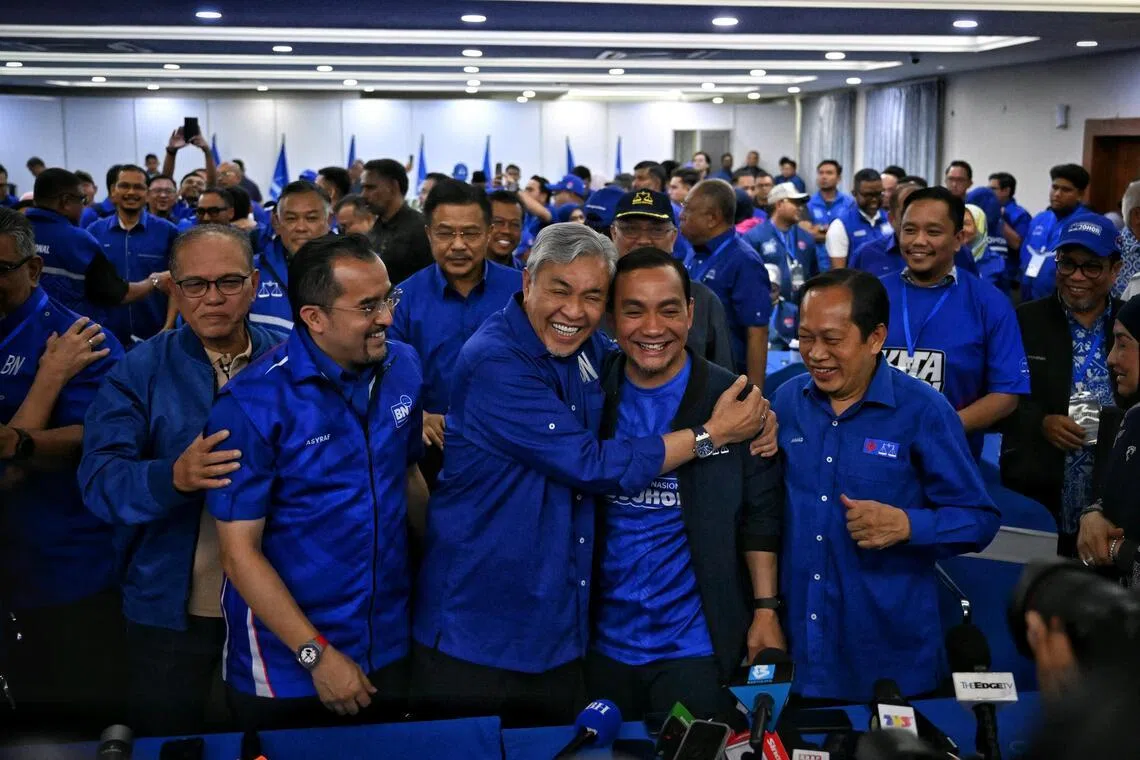 Barisan Nasional chairman Zahid Hamidi (third from left) hugging caretaker menteri besar Onn Hafiz Ghazi as the coalition takes early lead in the Johor state election.