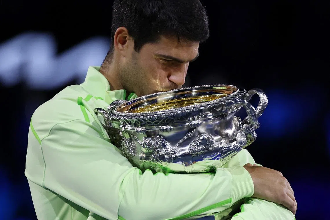 Carlos Alcaraz celebrating with the trophy after winning the Australian Open men's singles against Serbia's Novak Djokovic at Melbourne Park on Feb 1, 2026. Alcaraz becomes the youngest man to win all four Grand Slam titles.