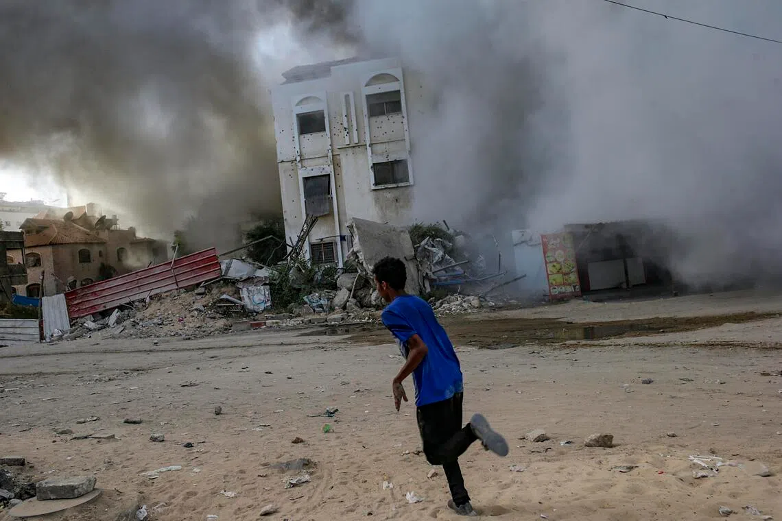 A youth running for cover amid an Israeli air strike in Gaza City on Oct 3.