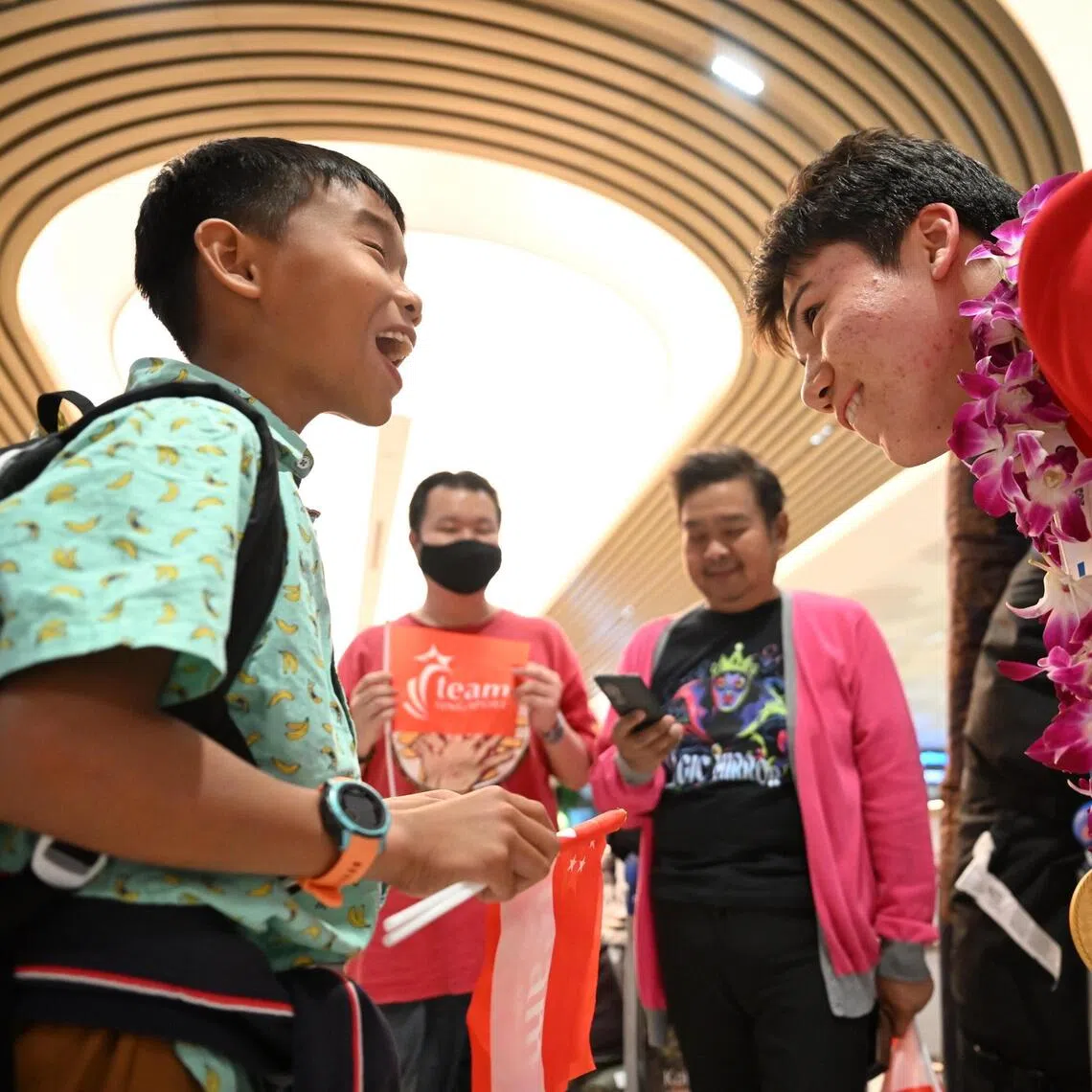 Max Maeder (right) chats with a young supporter, Ange Chew, 11 as the Singapore Sailing contingent arrives at Changi Airport Terminal 2, following following the conclusion of their 2025 SEA Games campaign on Dec 19, 2025.