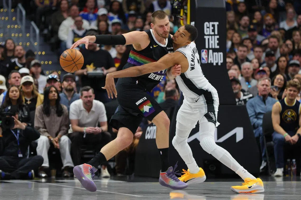 Nikola Jokic (left) and Victor Wembanyama of the San Antonio Spurs battling for the ball during the Denver Nuggets' 136-134 overtime NBA victory at Ball Arena on April 4, 2026, in Denver, Colorado.