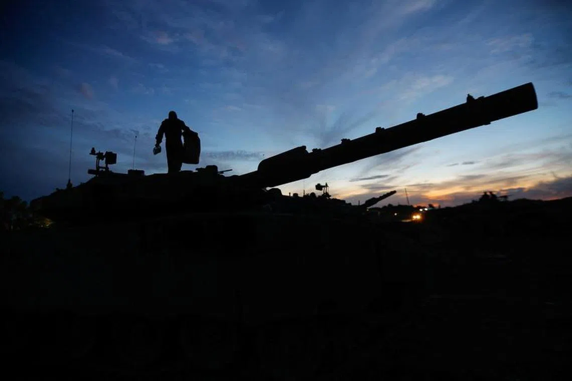 FILE PHOTO: An Israeli soldier walks on an Israeli tank near the Israel-Gaza border, amid the temporary truce between Hamas and Israel, in southern Israel, November 28, 2023. REUTERS/Alexander Ermochenko/File Photo