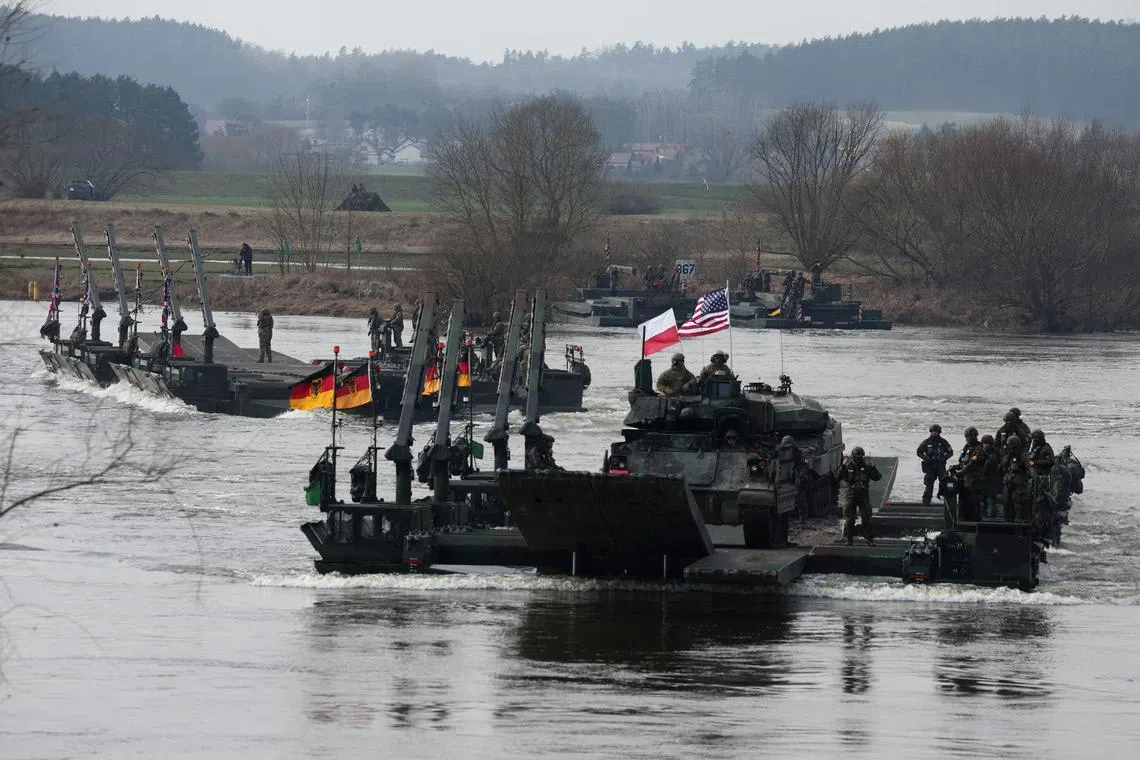 FILE PHOTO: German soldiers transport U.S. soldiers in an M2 Bradley infantry fighting vehicle as they cross Vistula River during NATO Dragon-24, part of the Steadfast Defender 2024 exercise, in Korzeniewo, Poland, March 4, 2024. REUTERS/Kacper Pempel/File Photo