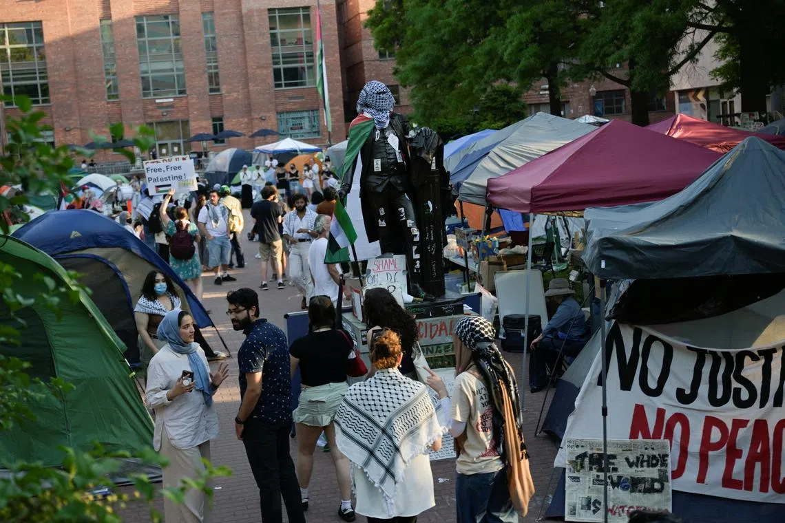 FILE PHOTO: People stand around a statue of George Washington tied with a Palestinian flag and a keffiyeh inside a pro-Palestinian encampment at George Washington University in Washington, DC, U.S., May 2, 2024. REUTERS/Craig Hudson/File Photo