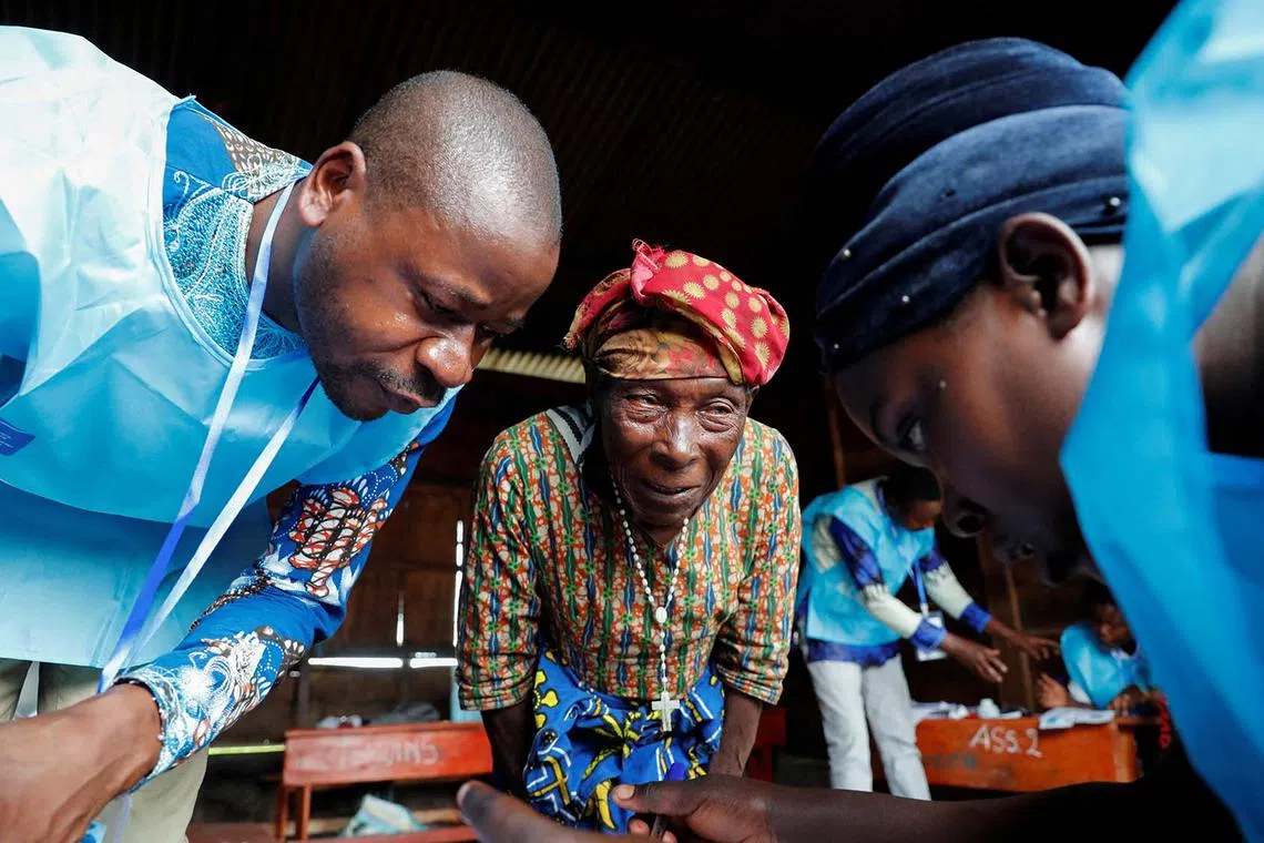 Masinda Nduru, a 98-year-old, internally displaced Congolese woman is processed by Independent National Electoral Commission (CENI) officials before voting at the Kanyaruchinya polling centre, during the Presidential election, at the Kanyaruchinya site for displaced people, in Nyiragongo territory, Democratic Republic of Congo, Decr 20, 2023. 