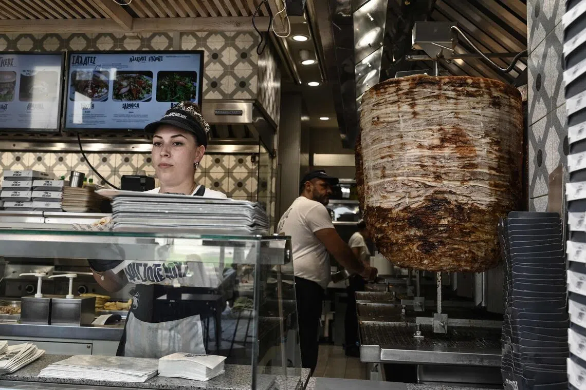 Employees work in a donner shop during a heatwave in Thessaloniki, Greece, on Aug 22.