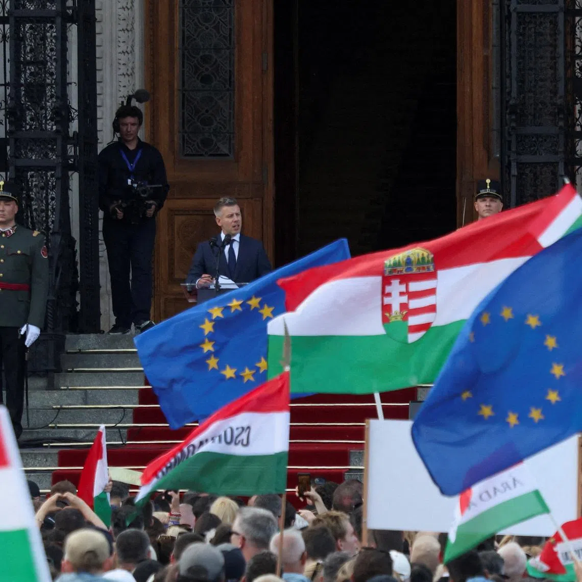 FILE PHOTO: People look on as Hungarian Prime Minister Peter Magyar delivers his speech in front of the Hungarian Parliament, after taking his oath of office, in Budapest, Hungary, May 9, 2026. REUTERS/Leonhard Foeger/File Photo