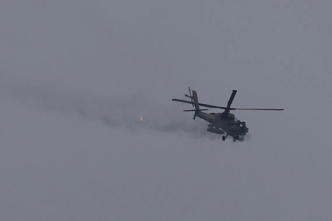 An Israeli helicopter fires its cannon, as seen from near the Israel-Lebanon border, in Israel, on May 5.