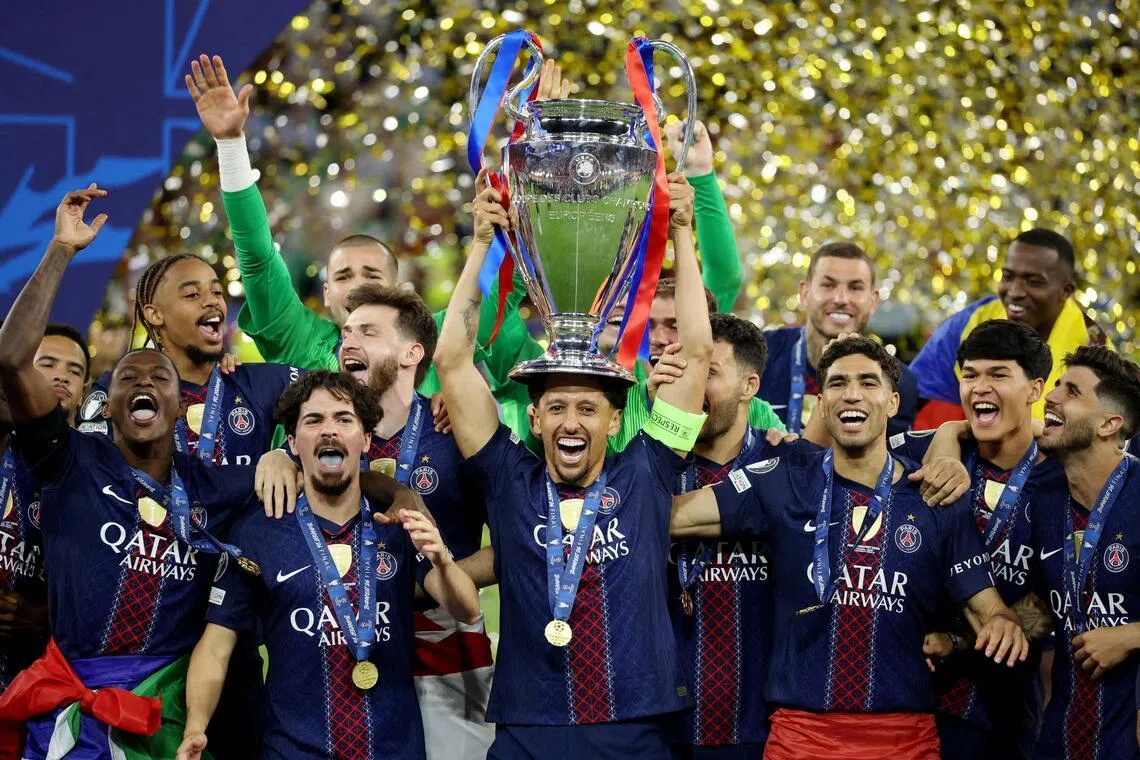 Paris St Germain's Marquinhos lifting the trophy on May 30, as he celebrates winning the UEFA Champions League with teammates.