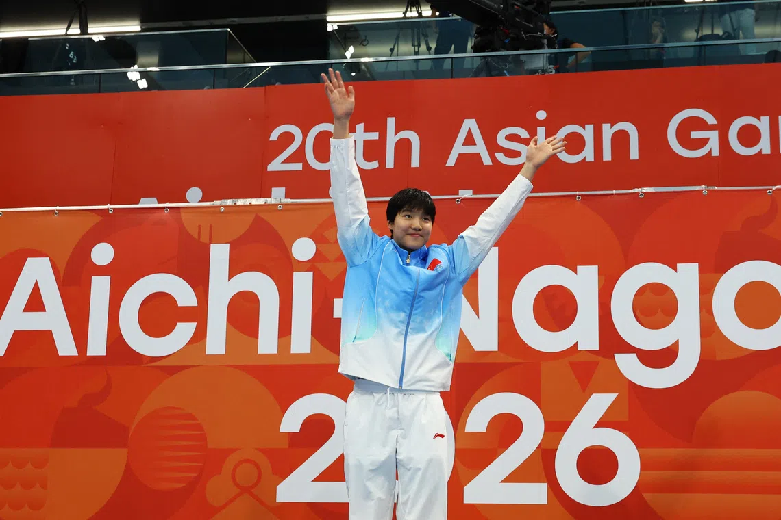 China’s Yu Zidi celebrates on the podium after winning gold in the the women’s 200m butterfly final.