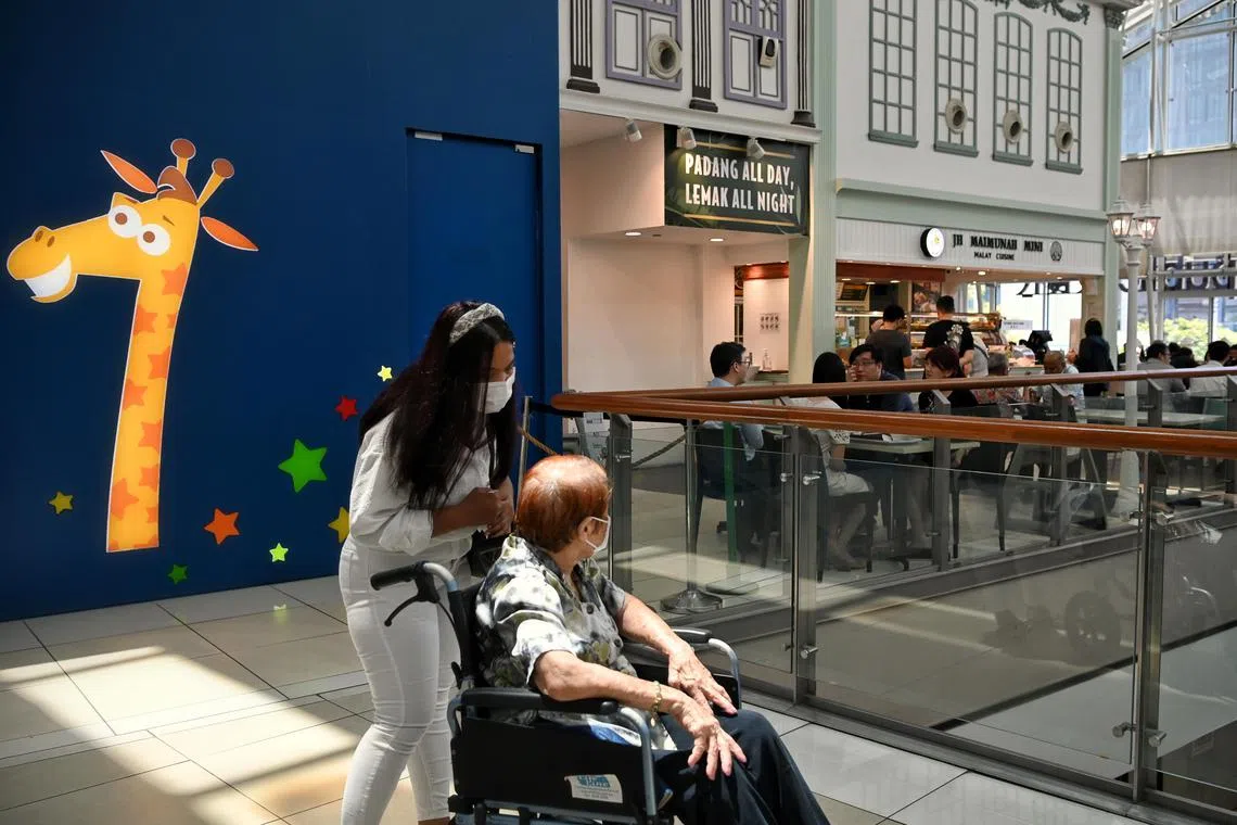 A maid with an elderly lady in a wheelchair at the Food Republic food court at City Square Mall on February 15, 2022.