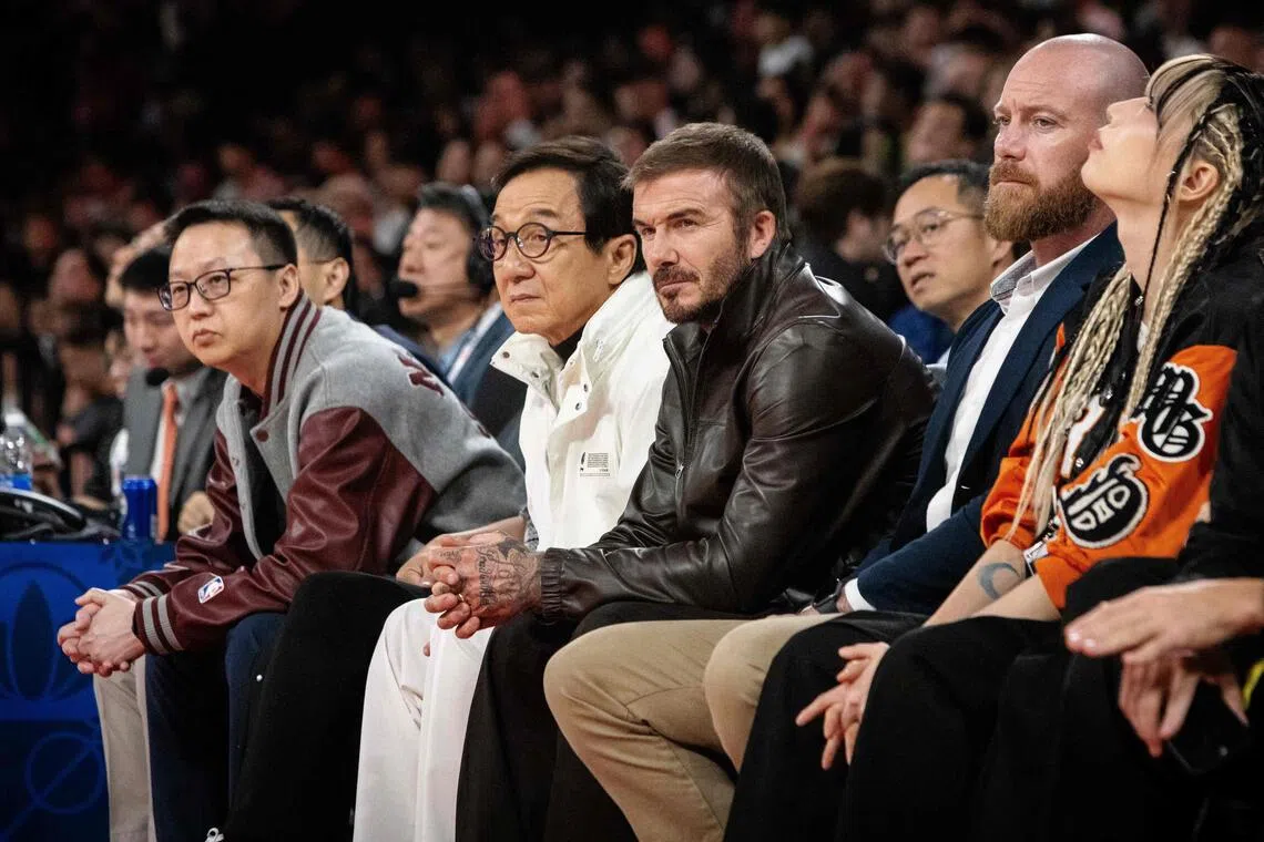 Jackie Chan and David Beckham watch from the front row the game between the Phoenix Suns and the Brooklyn Nets, at the Venetian Arena in Macau.