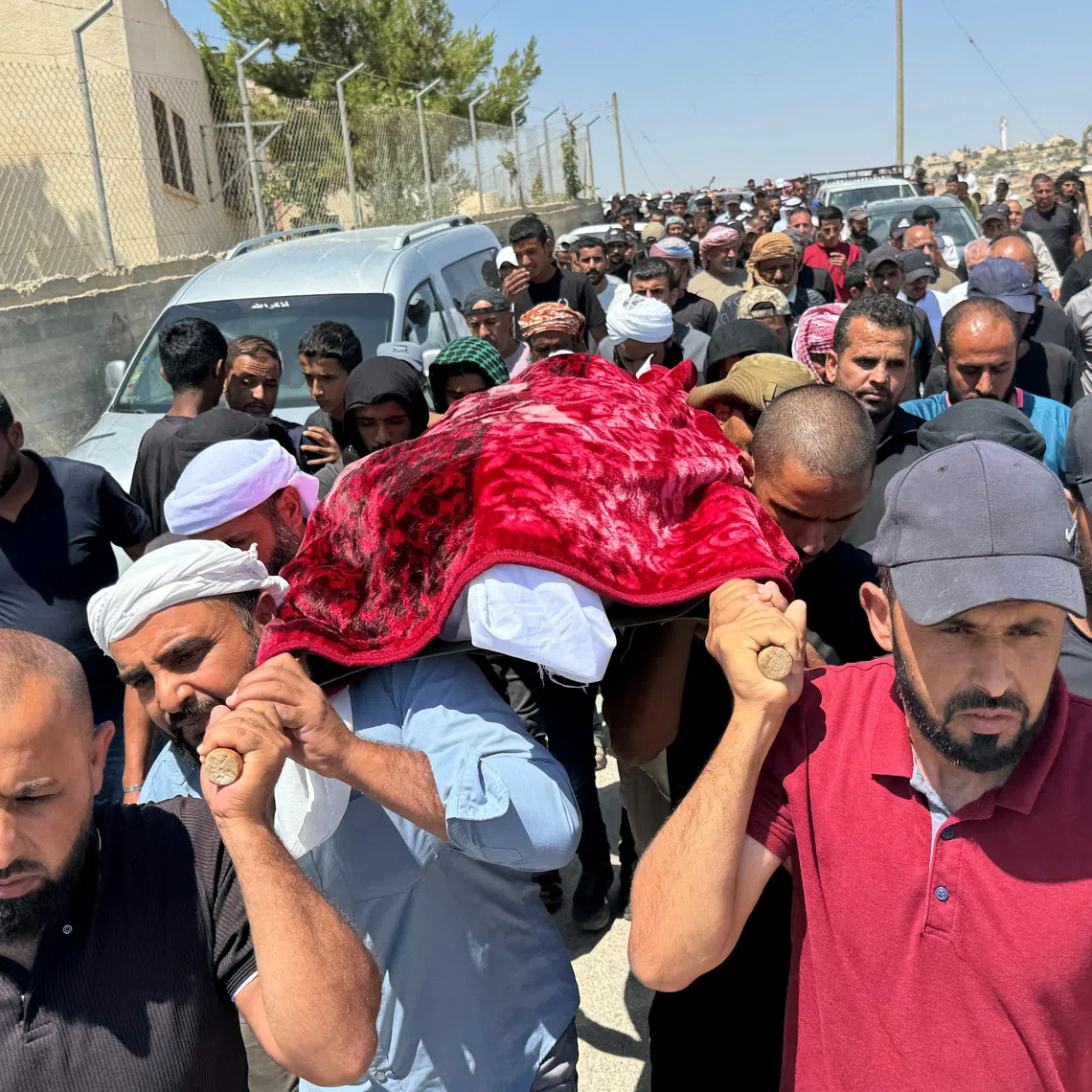 Mourners carry the body of well-known Palestinian activist Owdeh Hathaleen during his funeral near the city of Hebron in the Israeli-occupied West Bank on Aug 7, 2025.