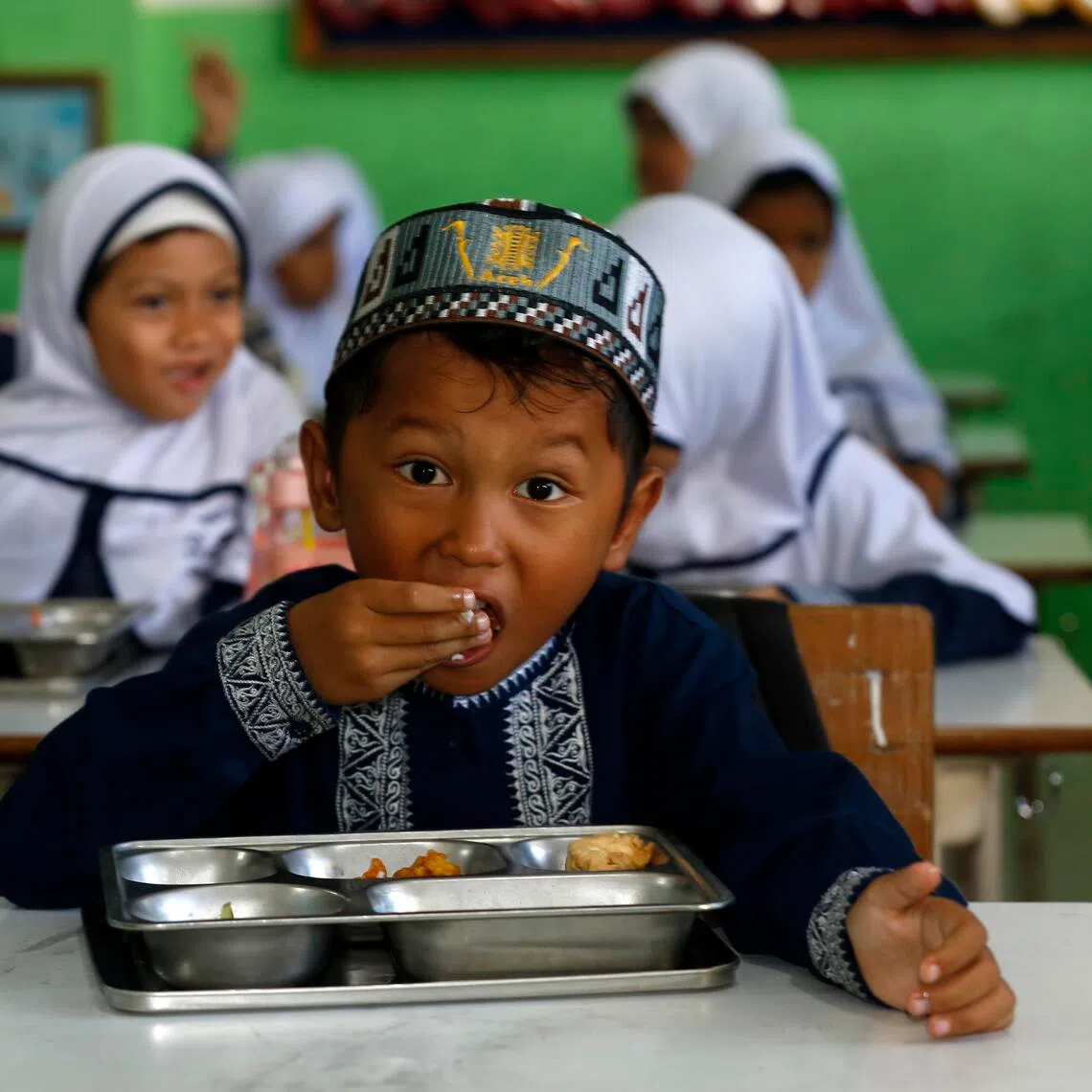 An Indonesian student eats a free meal at an elementary school in Banda Aceh, Indonesia, on Oct 30.