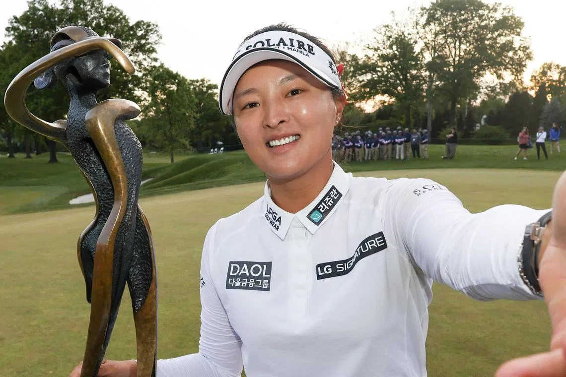 Ko Jin-young of South Korea imitates a selfie as she poses with the winner's trophy after a playoff win against Minjee Lee of Australia during the final round of the Founders Cup on Sunday. 