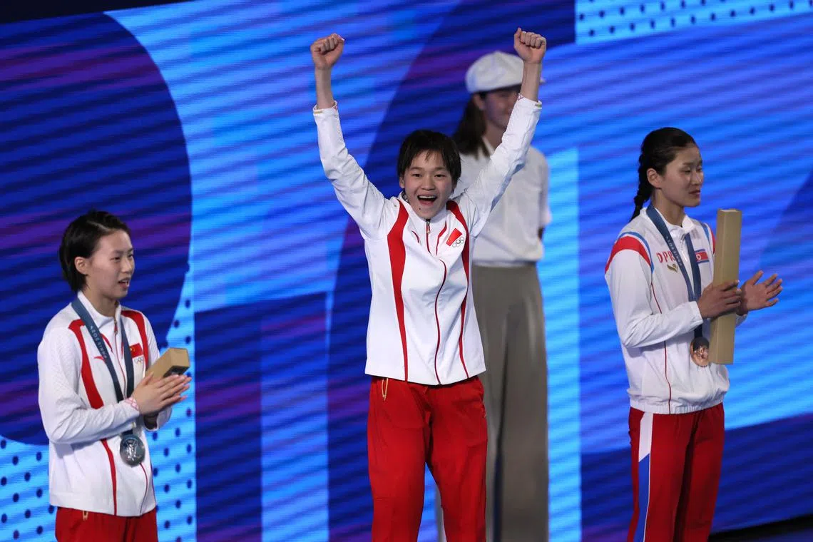 Paris 2024 Olympics - Diving - Women's 10m Platform Victory Ceremony - Aquatics Centre, Saint-Denis, France - August 06, 2024. Gold medallist Hongchan Quan of China celebrates on the podium with silver medallist Yuxi Chen of China and bronze medallist Mi Rae Kim of North Korea. REUTERS/Leah Millis