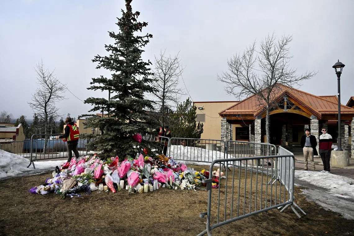 FILE PHOTO: Workers install a fence around a makeshift memorial for the victims two days after a deadly mass shooting took place at a school in the town of Tumbler Ridge, British Columbia, Canada, February 12, 2026. REUTERS/Jennifer Gauthier/File Photo